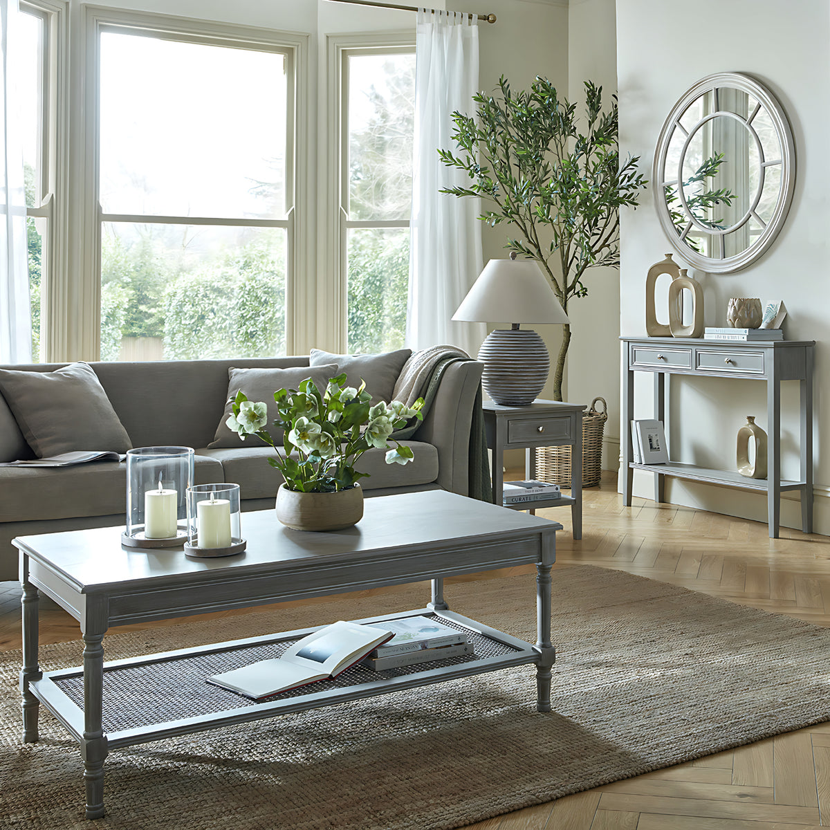 Living room with a gray sofa, coffee table, and decorative items.
